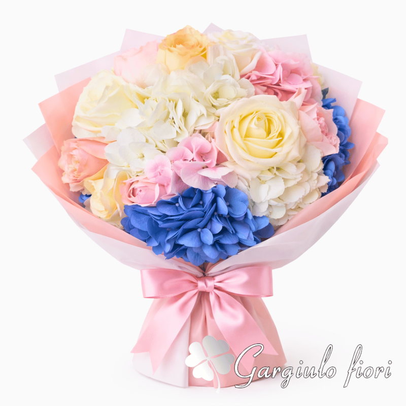 Bouquet pastello con rose crema, ortensia blu e ortensia rosa, incarto rosa